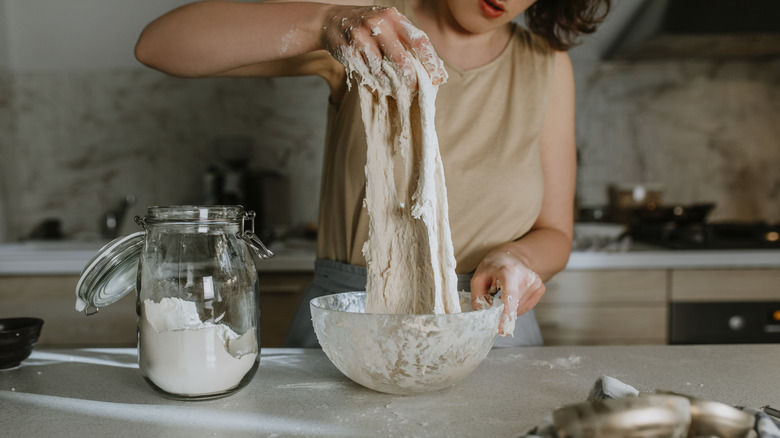 person working with sourdough in a kitchen