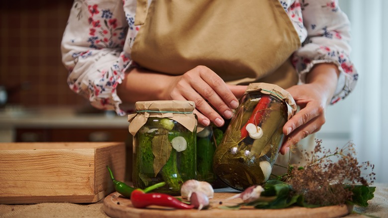 person examining jars of pickles in the kitchen