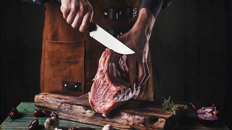 Cutting meat on wooden cutting board