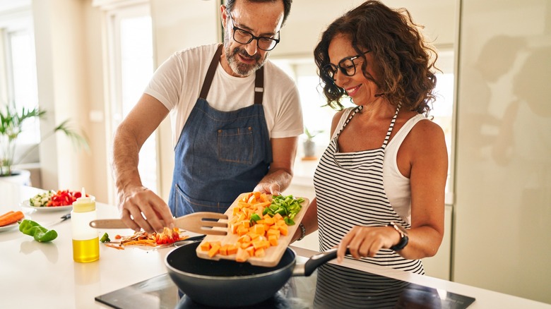 Couple uses cutting board in kitchen