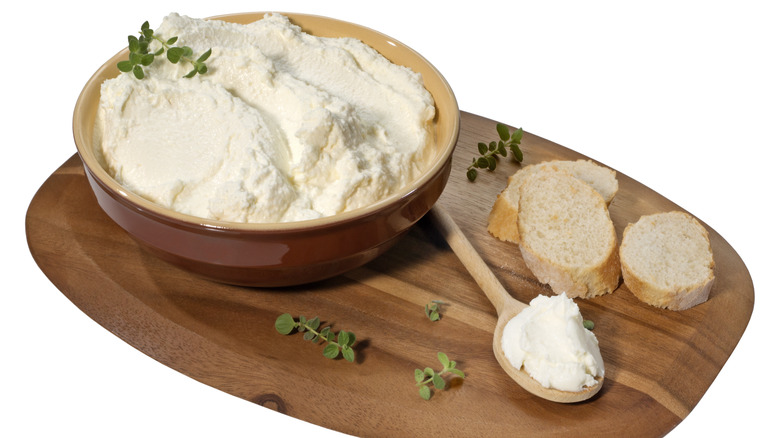 white cheese spread with bread on wooden tray