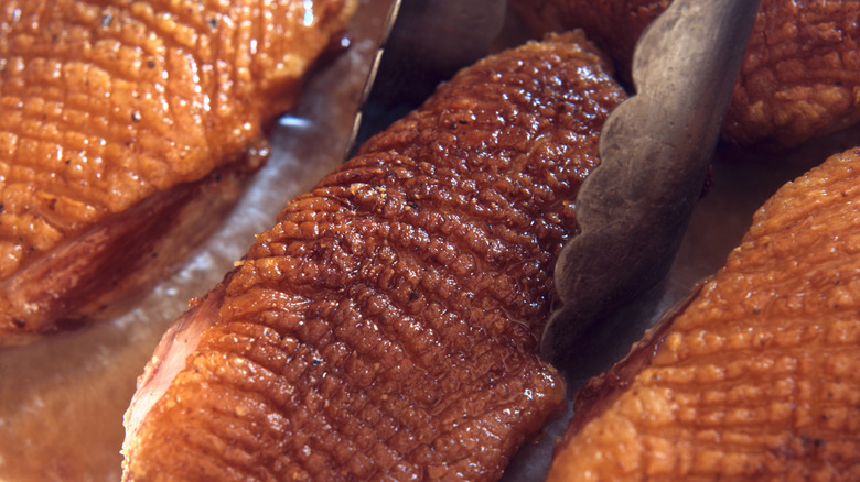 Cooked duck breast with fine crosshatch pattern scored into skin