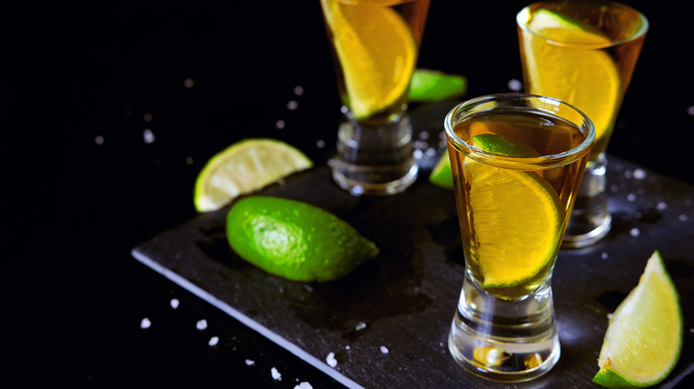 Tequila shots with lime wedges in the glasses