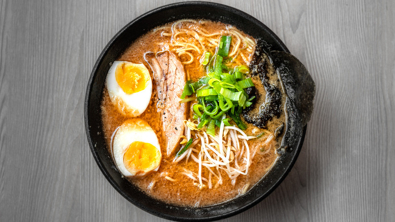 bowl of ramen with eggs, scallions, pork and seaweed