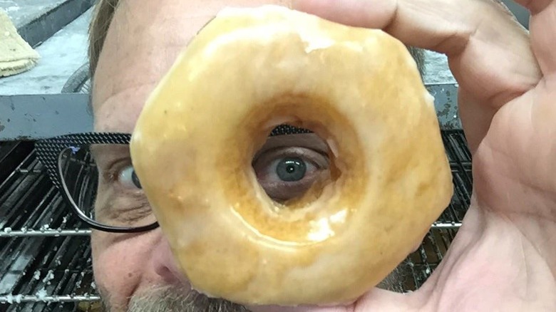 Alton Brown looks through donut