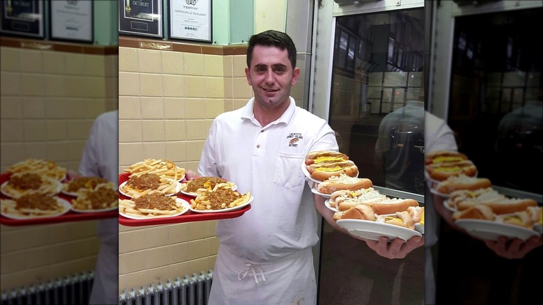 Lafayette Coney Island server holding orders of Coney dogs and fries