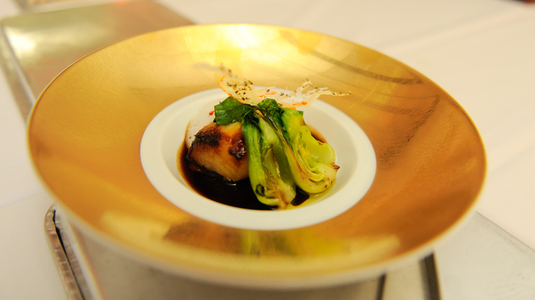 Fish and leeks served on a gold plate