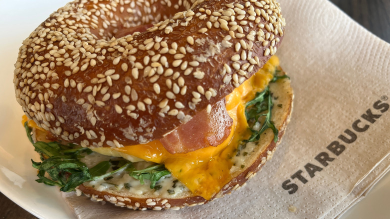 A Starbucks breakfast sandwich sitting on a brown branded napkin