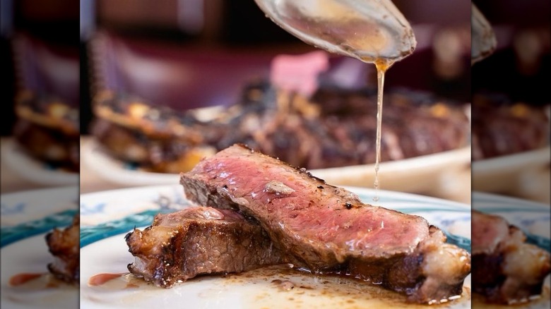 Pouring jus over steak slice