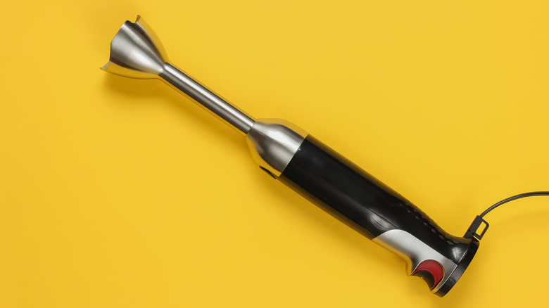 An immersion blender on yellow background