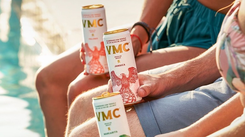 Hands holding three flavors of VMC by the pool