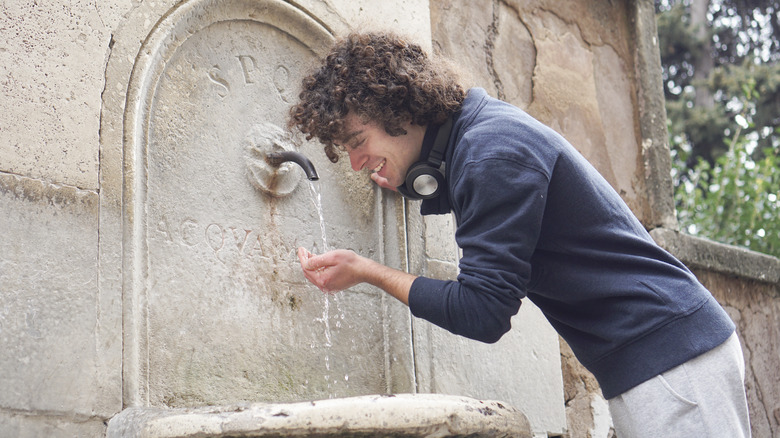 Man drinking out of fountain