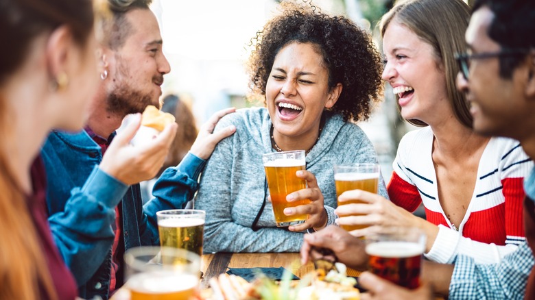 people laughing holding beer glasses