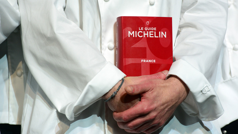 Chef cradling the Michelin Guide in hands