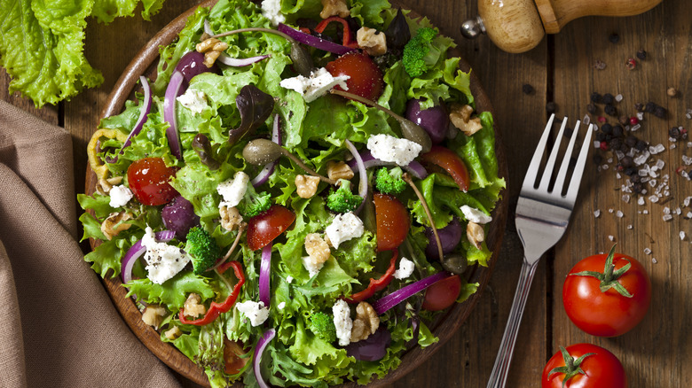 greek salad in bowl next to fork