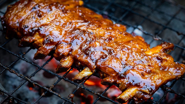 Rack of pork ribs cooking on a hot grill