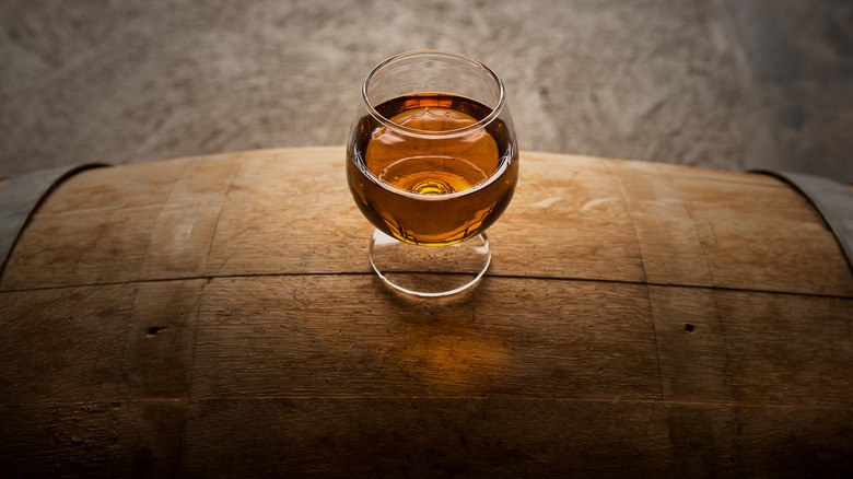 Glass of whiskey on barrel