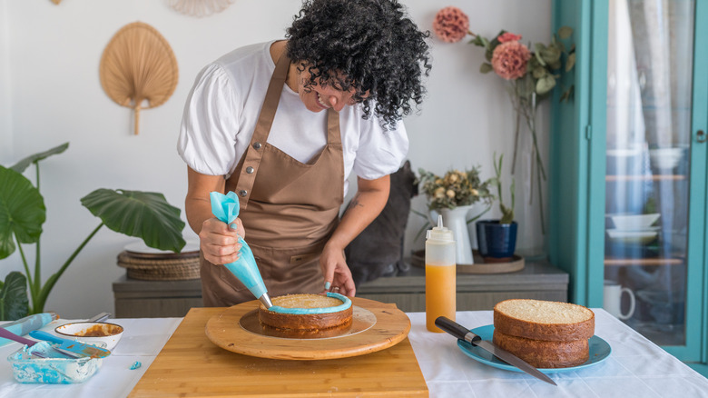 woman decorating cake on lazy susan