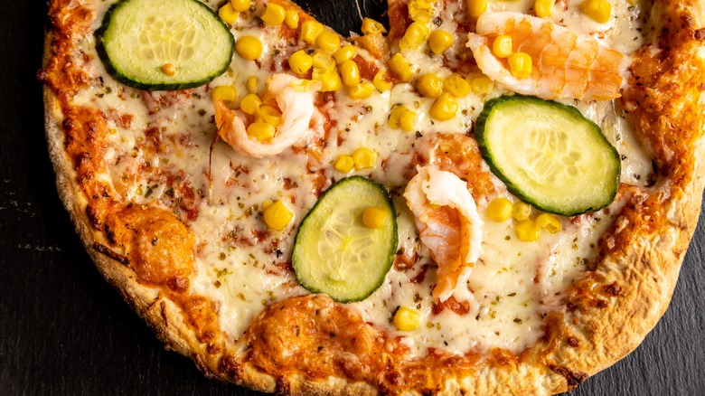 Pizza with corn, shrimp, and cucumber