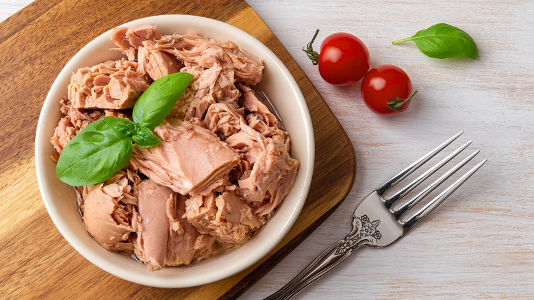 canned tuna in a bowl with tomatoes and herb