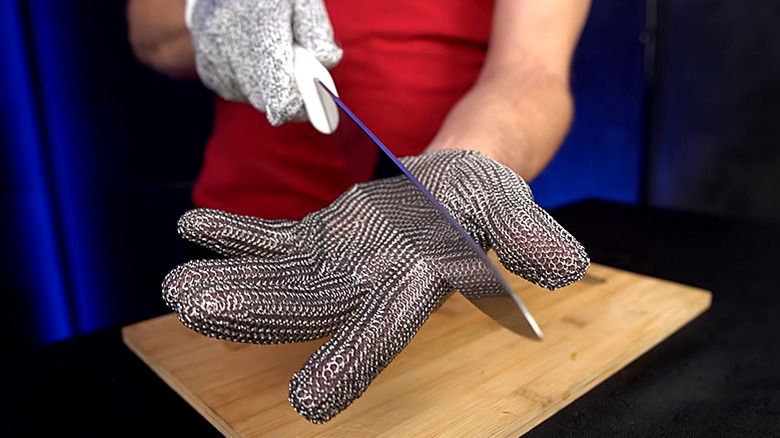 metal chainmail cut resistant gloves holding knife