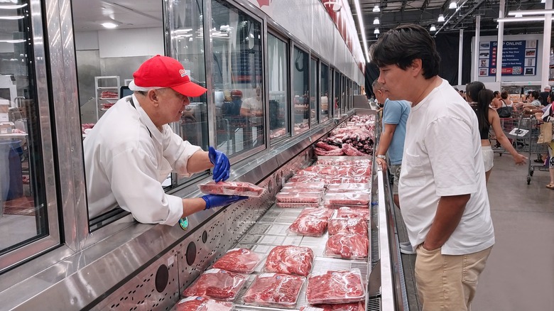 Costco employee talks to shopper in meat department