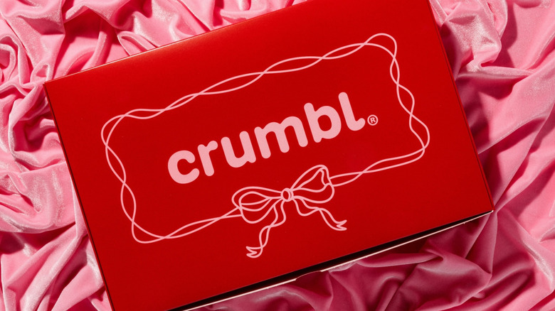 Crumbl's special-edition Red Box for Valentine's Day sits on a pink velvet background