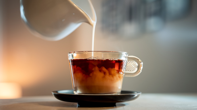 Tea with milk being poured in