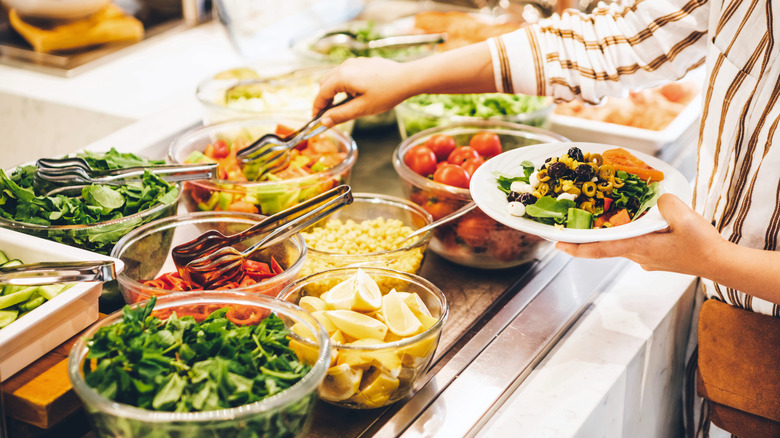 Woman choosing salad at a salad bar