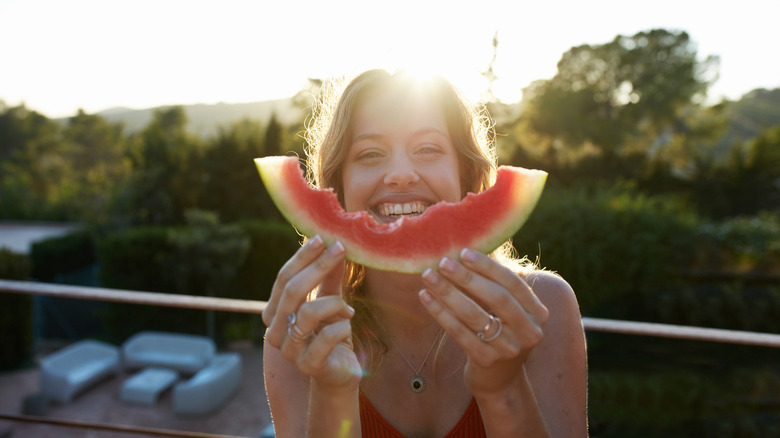 Smiling woman holds a watermelon rind