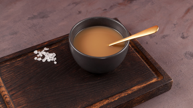 Cup of tea next to salt or sugar crystals