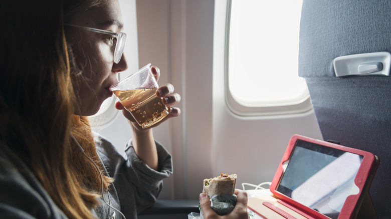 woman drinking ginger ale in-flight