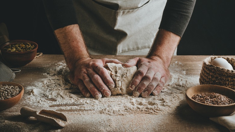 Hands kneading dough wood counter