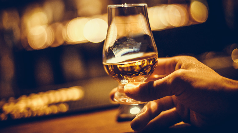 Hand holding a Glencairn whiskey glass