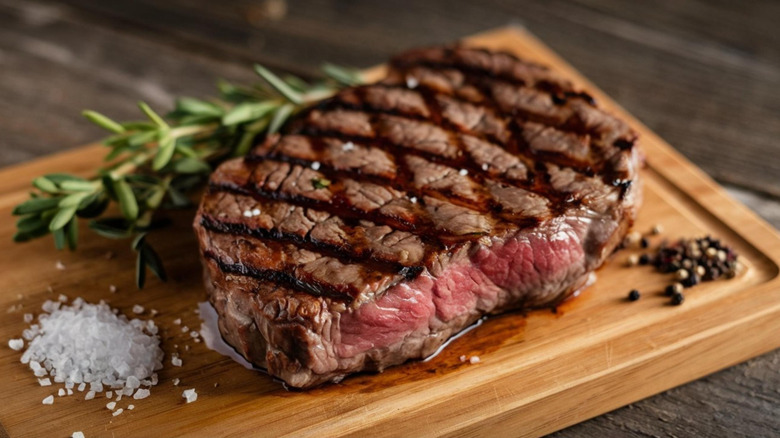 Grilled steak with crosshatch marks on a wooden board