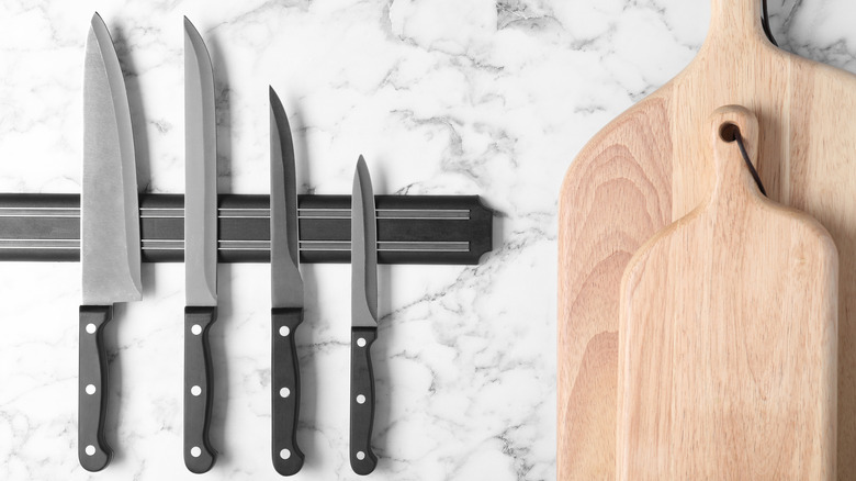 Set of knives on magnetic strip in kitchen