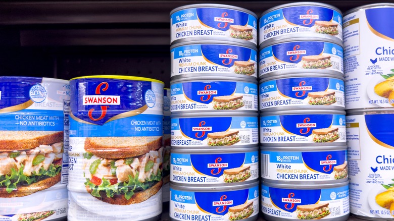 Cans of chicken on store shelf