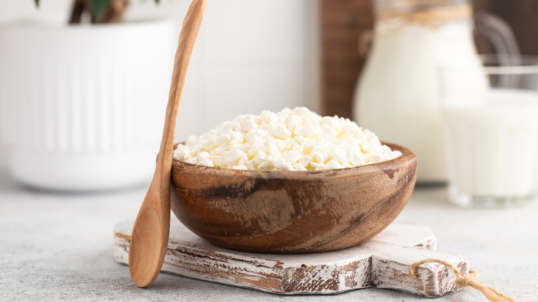 Homemade cottage cheese in a wooden bowl with spoon