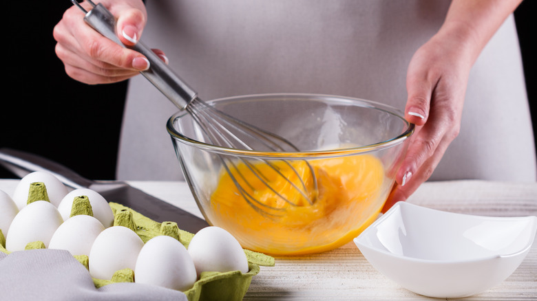 woman's hands whisking eggs