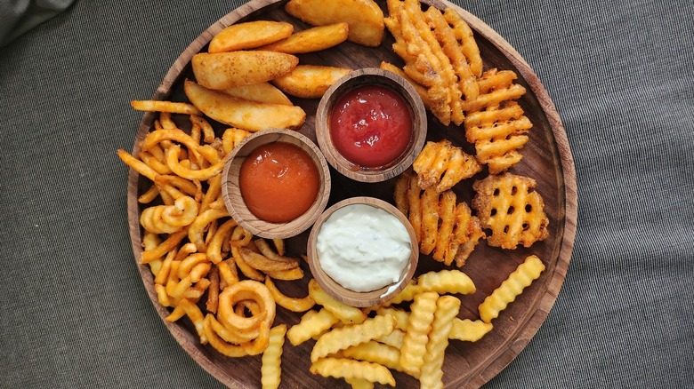 Various fry shapes on a dish with dipping sauces.