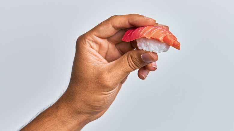 hand holding tuna nigiri