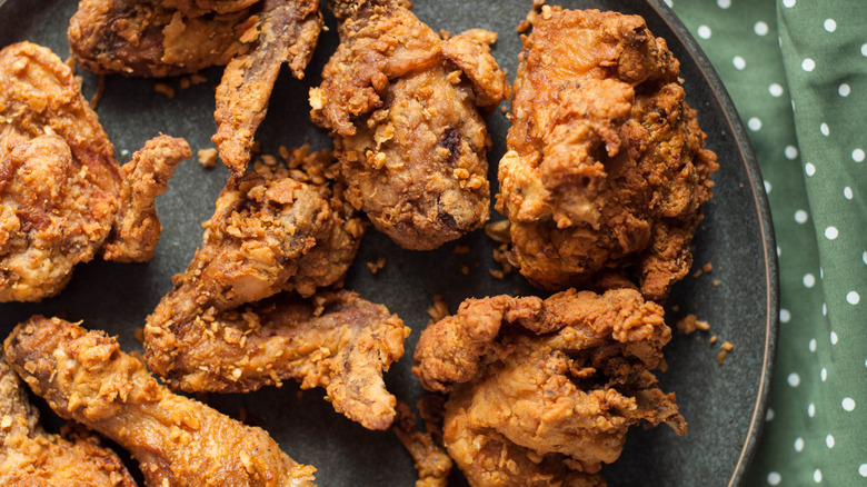 Plate of fried chicken on a green tablecloth with white polka dots.