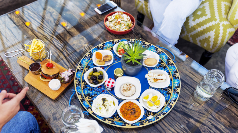 a table with a communal plate of food and other dishes