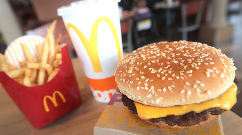 A McDonald's meal including a fry, drink, and quarter pounder on a table