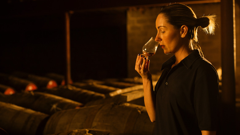 Woman sniffing glass of whiskey