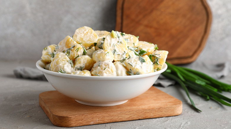 A bowl of potato salad with herbs