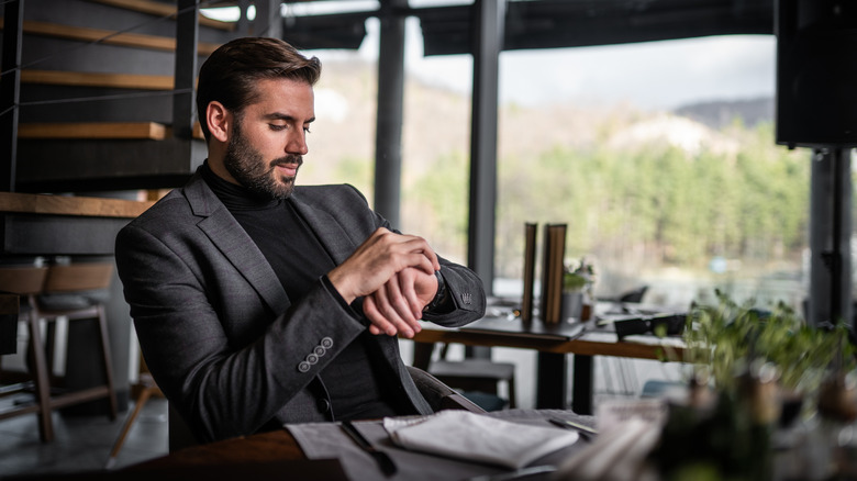 Businessman checking his watch at dinner table