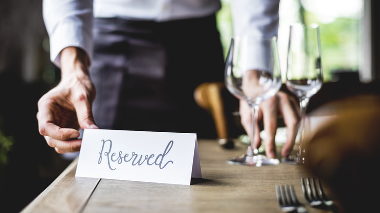 Man placing reserved card on table