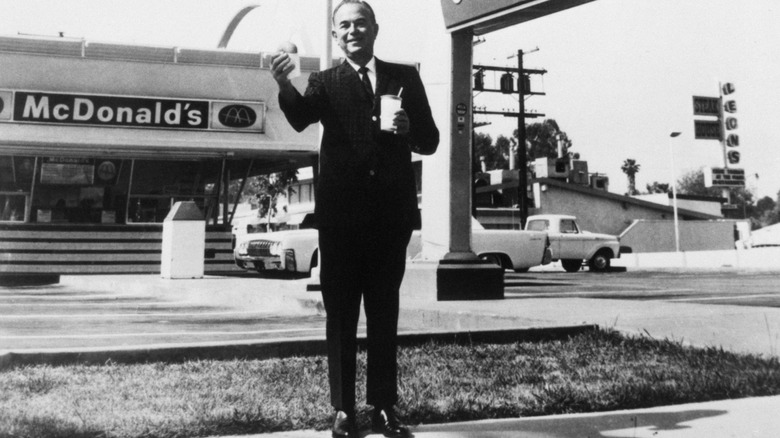 Ray Kroc stands outside one of the original McDonald's restaurants