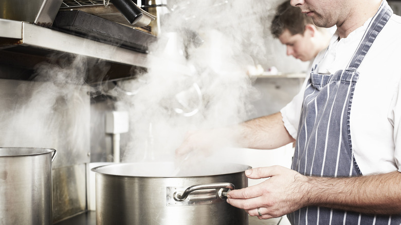 Chefs boil water in kitchen